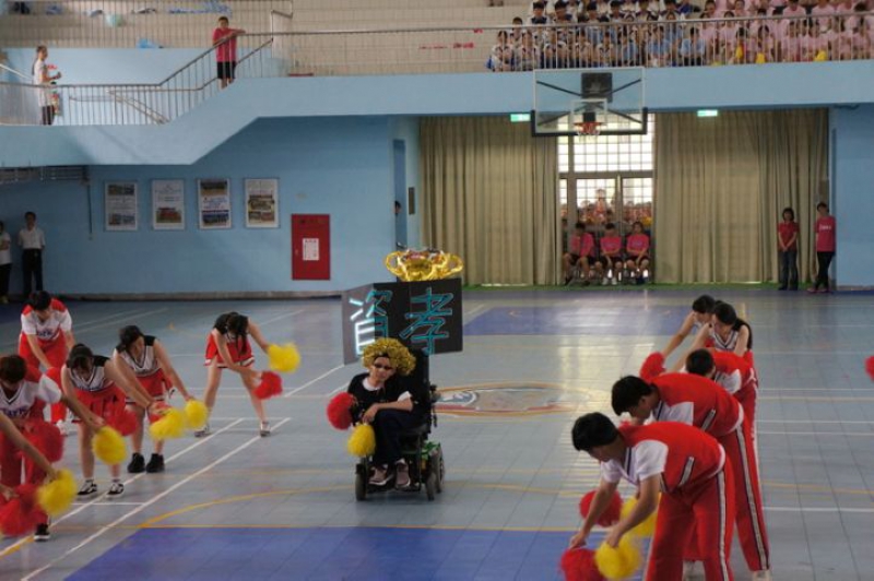 高二啦啦舞比賽時，同學為不能跳舞的吳宗翰打扮，安排他舉班牌登場。