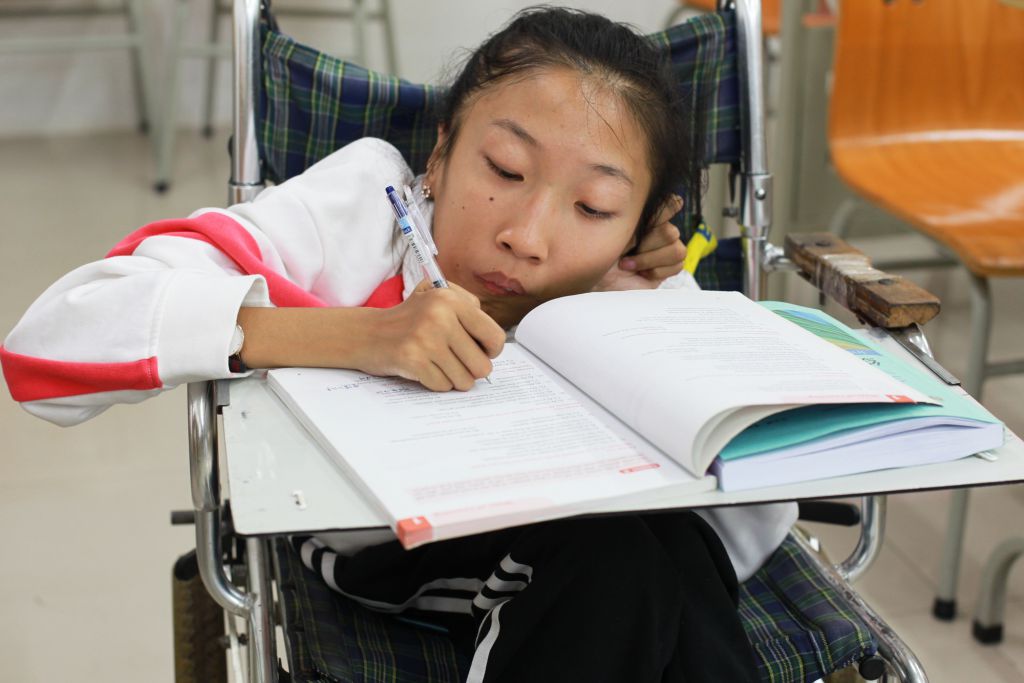 轮椅上加一块板子，就是徐瑞阳的课桌了