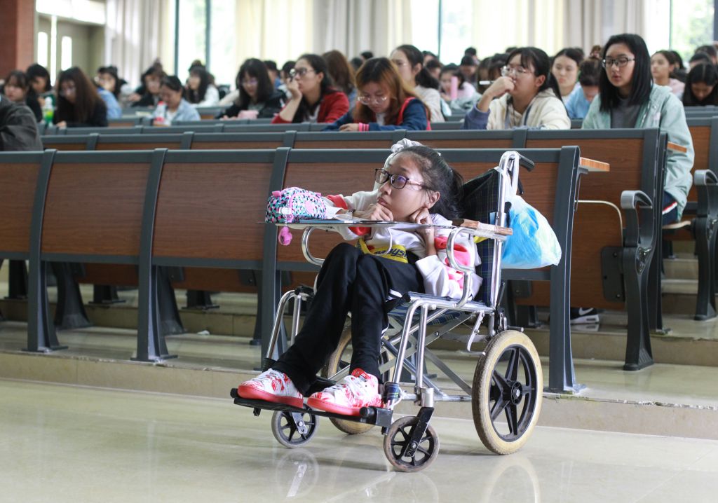 在阶梯教室上大课时，同学们也习惯了有一位坐在轮椅里上课的同学