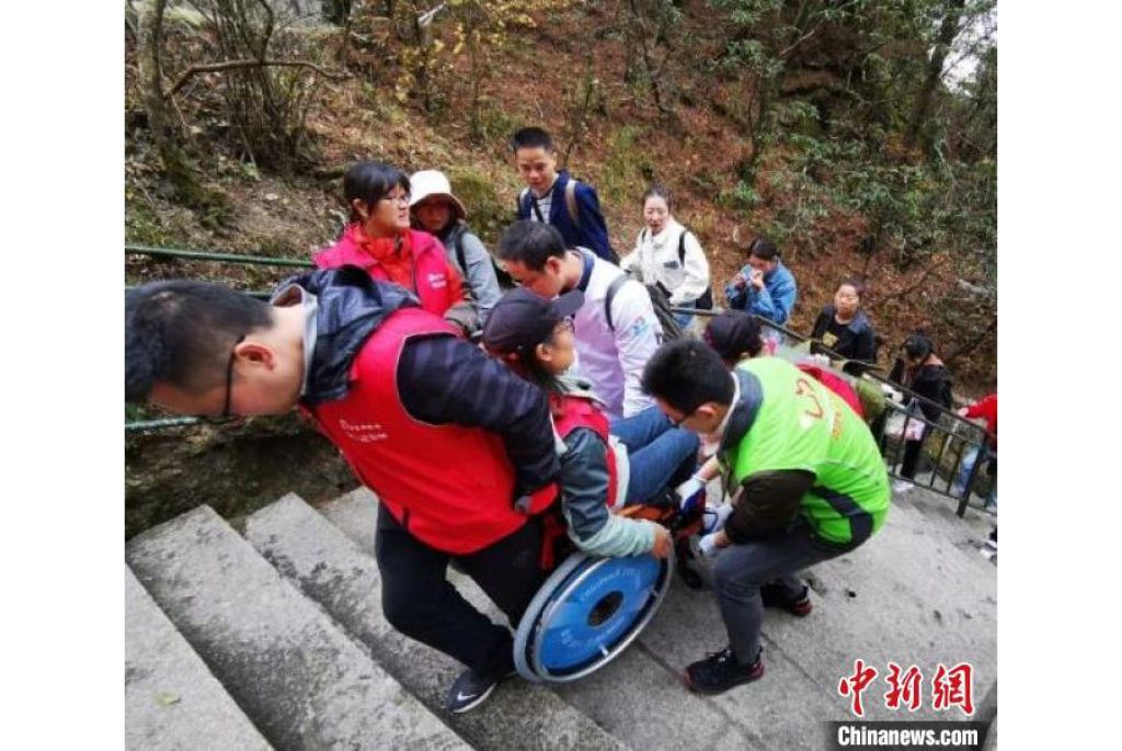 “輪友”在志願者的幫助下登山