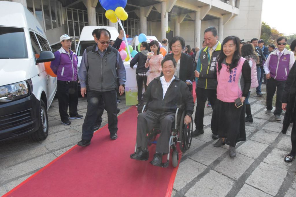 县长王惠美推著轮椅协助行动不便朋友搭乘复康巴士