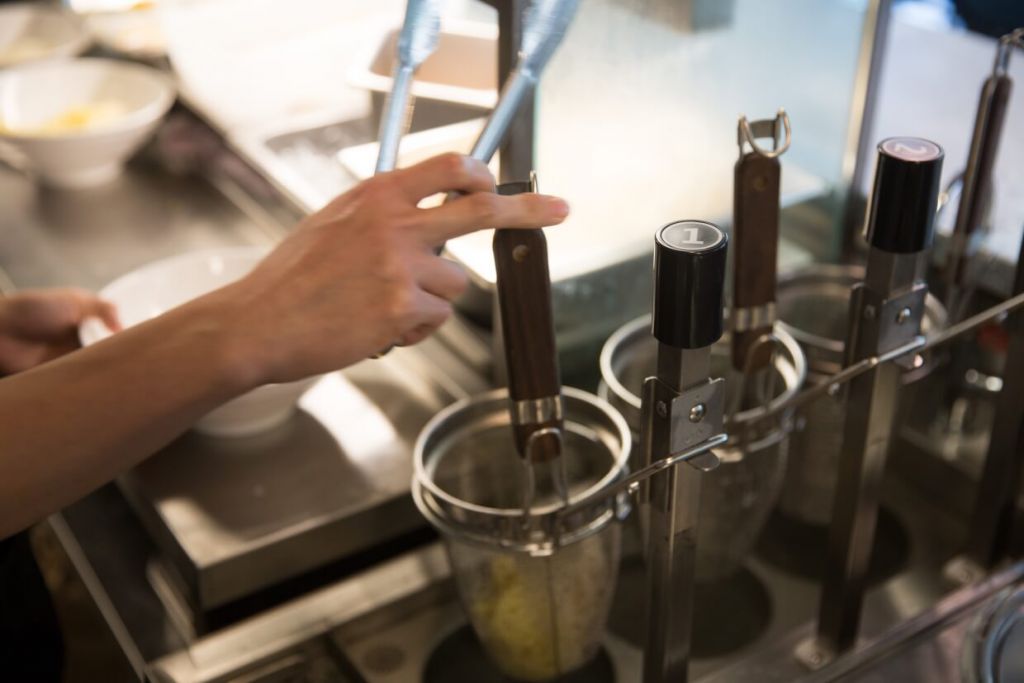 按一下，盛載麵條的機械便徐徐落下，自動計時。時間一到，再自動彈起。