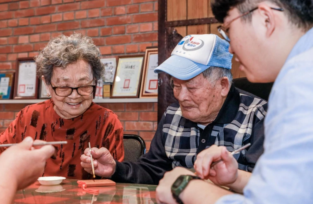 旅遊中，高齡父母親在彰化花壇橋頭社區體驗古早製磚風情、中國結磚瓦描金。