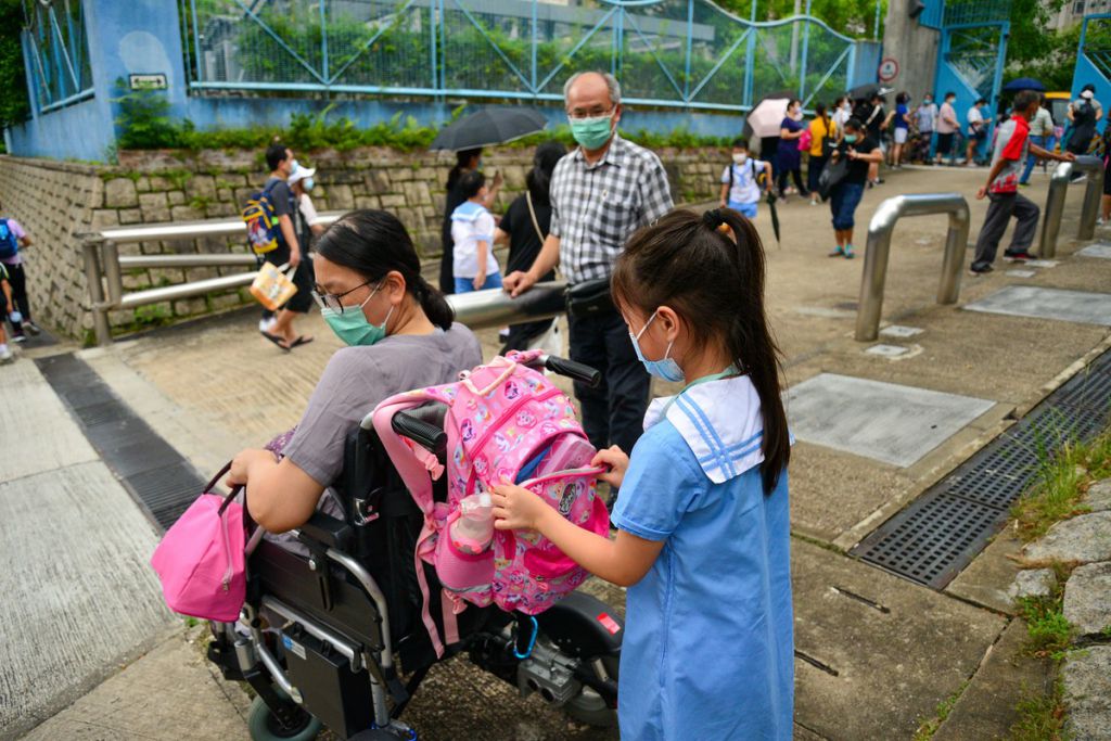 丽君在接送一位托管小女孩放学（此为摄影师张靖宜所拍摄）