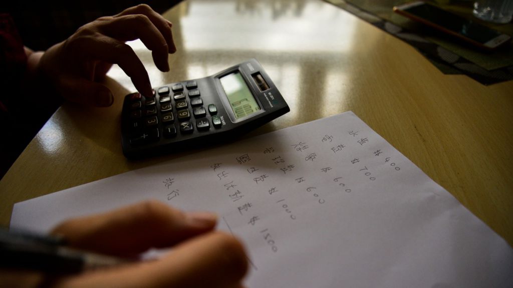 丽君虽然行动不便，但她会在家庭岗位中担任协调及统筹，例如计算一下家中的开支收入（此为摄影师张靖宜所拍摄）