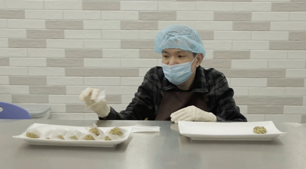 智障人士恩庭控制肌肉也有一定困難，工作人員也難於助他載手套，現在能更易戴手套便能參與食物處理工作。