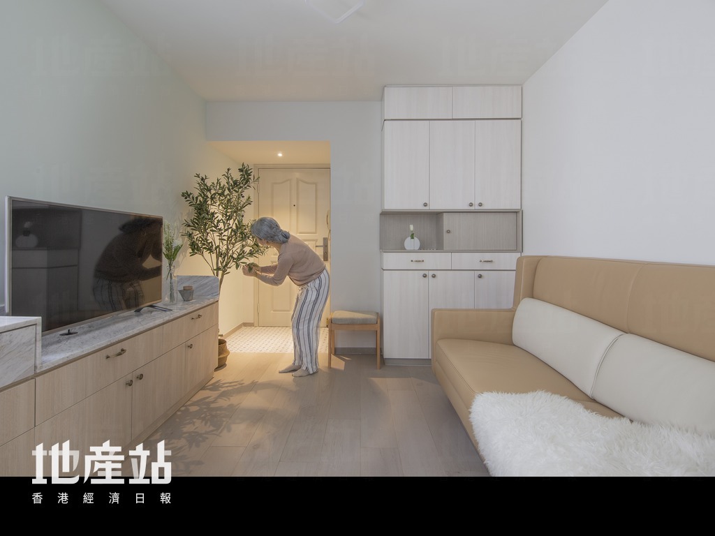 客厅就在玄关前，设计师以连体式家俬规划电视柜之馀，亦预留了空位方便屋主打理植物。